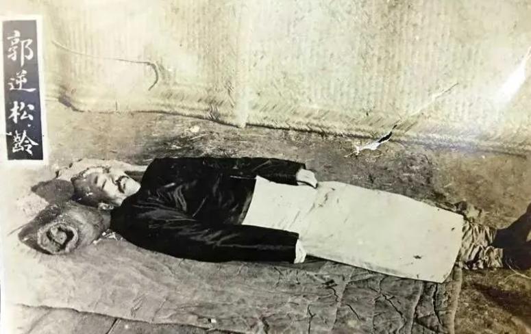 1925 年，郭松龄被枪决后的遗体照片，穿着长袍马褂身下铺着草席。这个场景令人感
