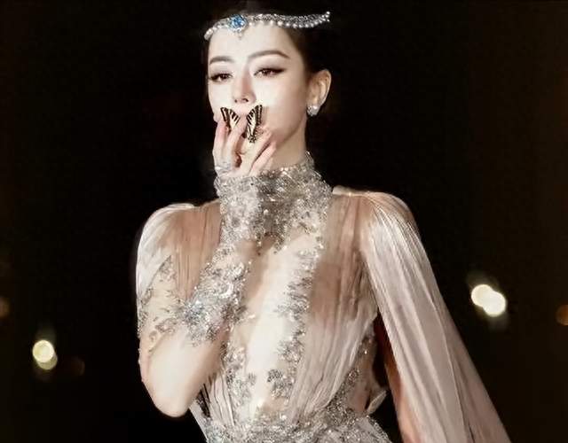 迪丽热巴嘴衔蝴蝶惊艳亮相红毯，八秒镜头出圈，全网热议蝴蝶真假