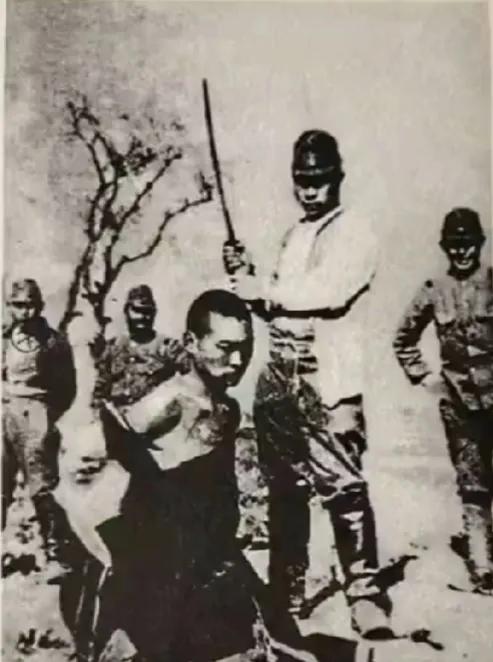 一张令人愤恨的图片！
面对镜头，日军挥起屠刀，准备砍杀被缚的南京青年，围观的日军