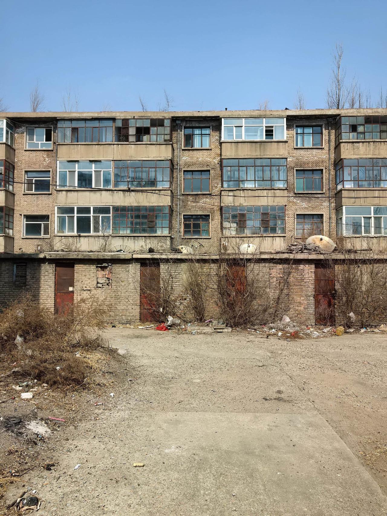 这里是大同肉联加工厂家属院里的楼房。人都走光了，只剩两三户了。西北风轻轻吹过，门