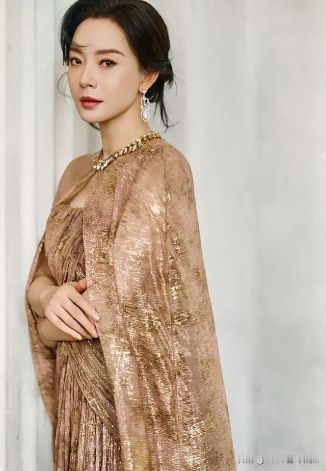 香槟流光织就摇曳长裙，璀璨金饰点缀倾城。青丝挽起从容，眼波流转典雅。在静谧光影里