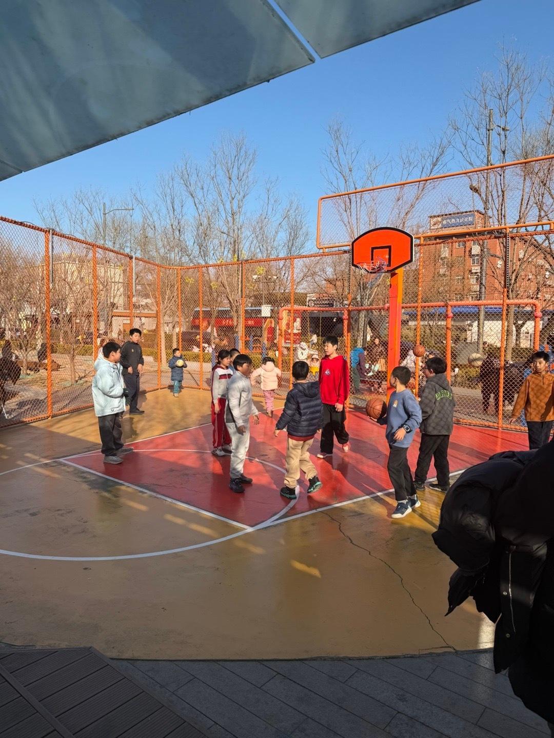 北京，西单商圈，老佛爷商场斜对面的街边篮球场。大人小孩，男孩女孩，都在这寸土寸金