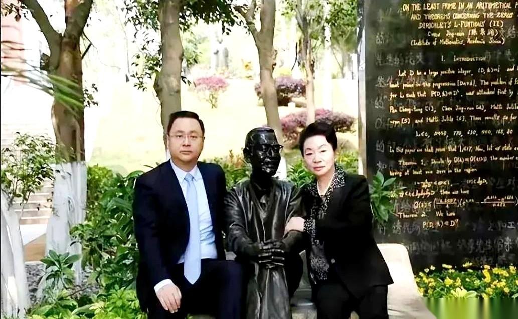 厦门大学，雕像前。一个白衣女人，低头，把花轻轻放在铜像基座。旁边站着个高大男人，