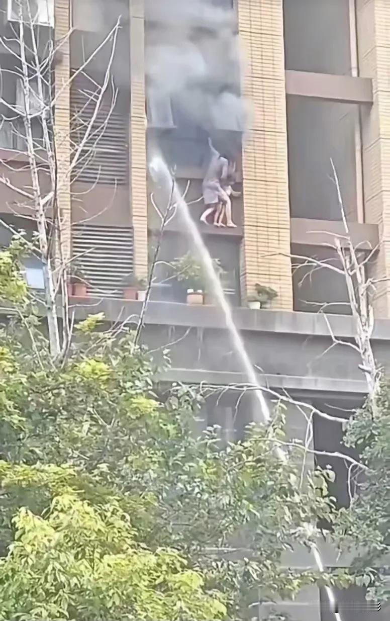 一位年轻的母亲面对浓烟、恐高，也要护住自己孩子，那种无助让人心碎。那么窄的墙边，