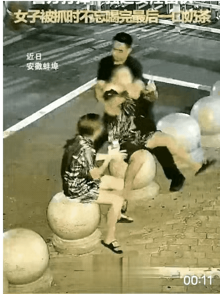 一男一女坐在石墩上突然被抓，没看明白犯了啥事，女的即便在被抓时，还没有忘记喝一口
