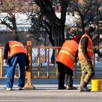 吉林街头，一群环卫工在零下8度的寒风里弓着腰擦马路护栏，棉服裹得再厚也挡不住冷意