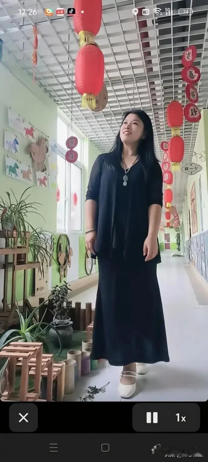在充满童趣的教室里，黑色长裙搭配白色鞋子，优雅又舒适。