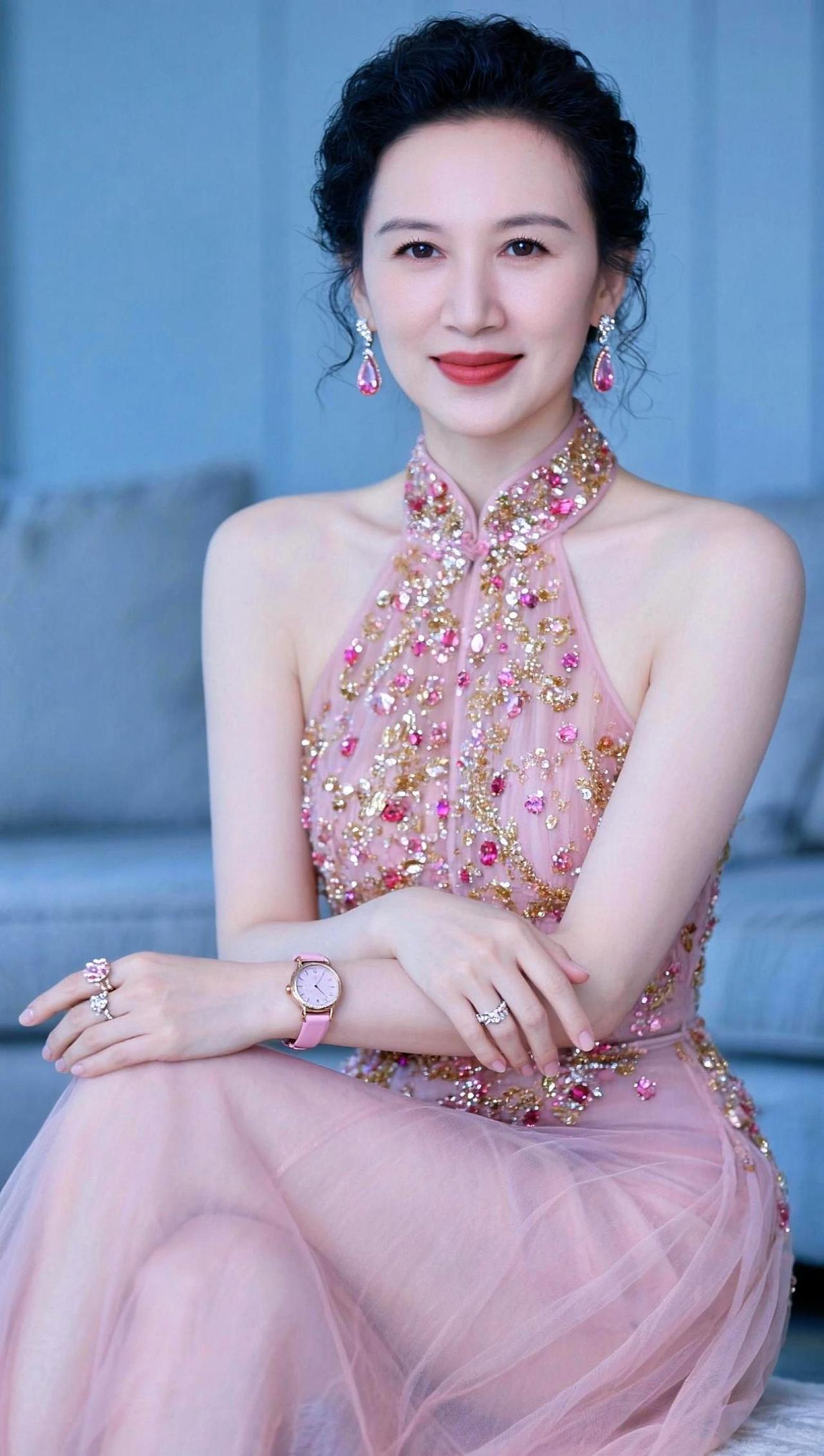 这优雅的姿势，仿佛在说：“姐的美丽不需要滤镜。”一袭粉色长裙，闪耀的配饰，这哪是