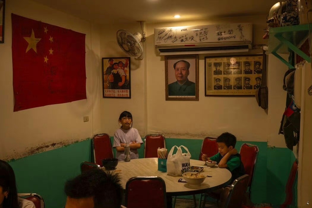 台湾桃园的一家餐厅，墙上挂着中国国旗与教员的头像，这里居住着1949年从大陆败退