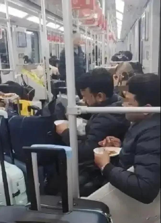 上海地铁，几名外籍乘客竟公然在拥挤的车厢里摆开阵仗，用手抓着咖喱饭大快朵颐。刺鼻