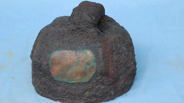 在文登博物馆，静静陈列着一枚看似普通的铁疙瘩，它浑身布满铁锈，模样如同大秤砣，实