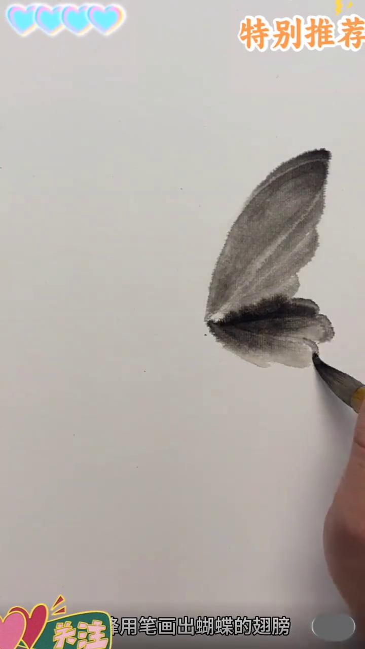 蝴蝶画法。
·笔度淡墨，笔尖调中浓墨。
·侧方用笔画出蝴蝶的翅膀，这时加墨画出蝴