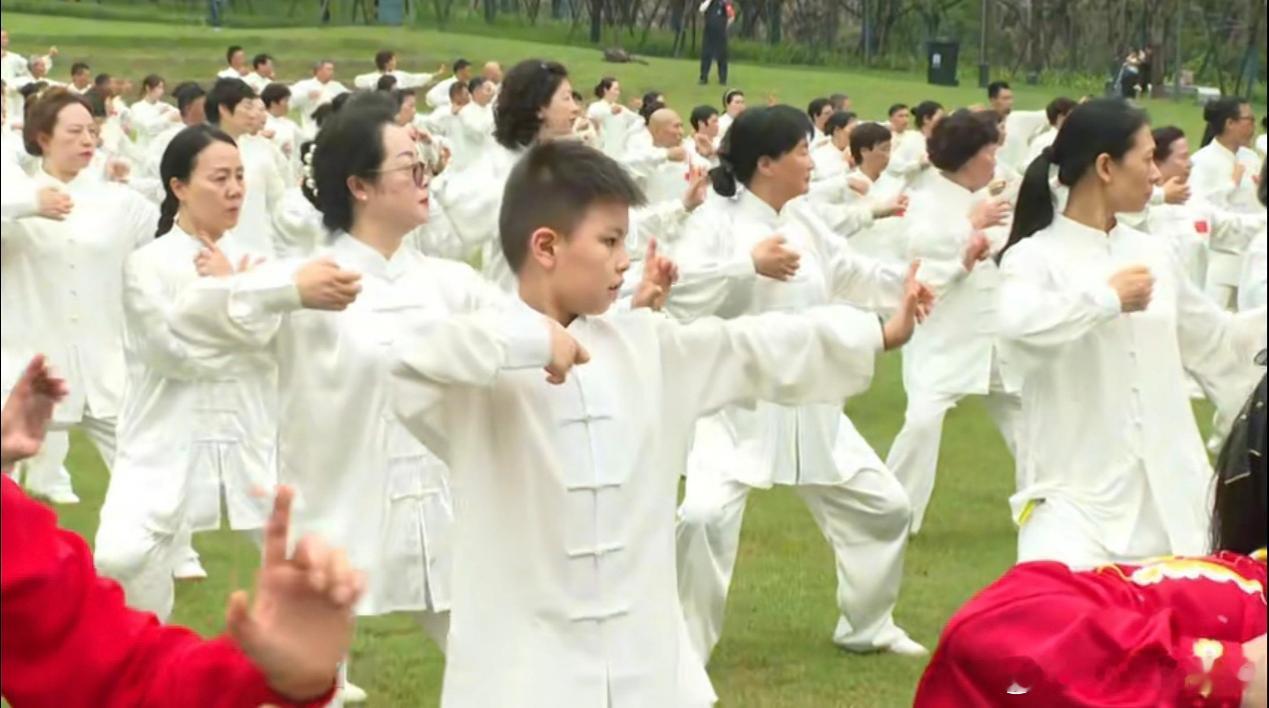 拿着手机看世界强城在行动 近日，“世界风·太极韵”——温州园博园千人太极展演暨园