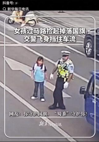 湖北阳新马路上车水马龙，一小女孩突然横穿马路，来到马路中间捡什么东西，执勤的交警