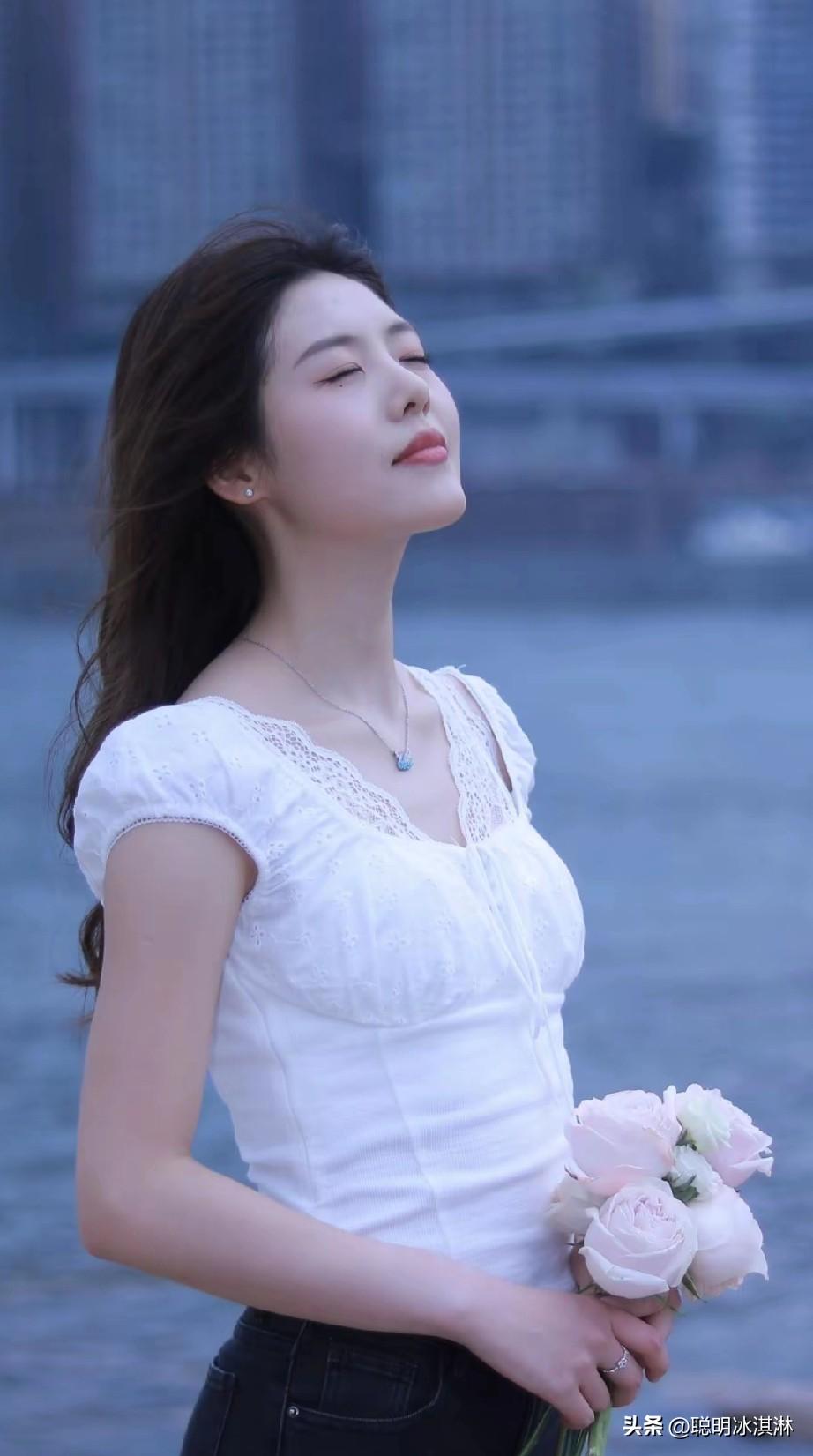 少女心满满，手捧粉色花束，享受微风拂面的美好时光。