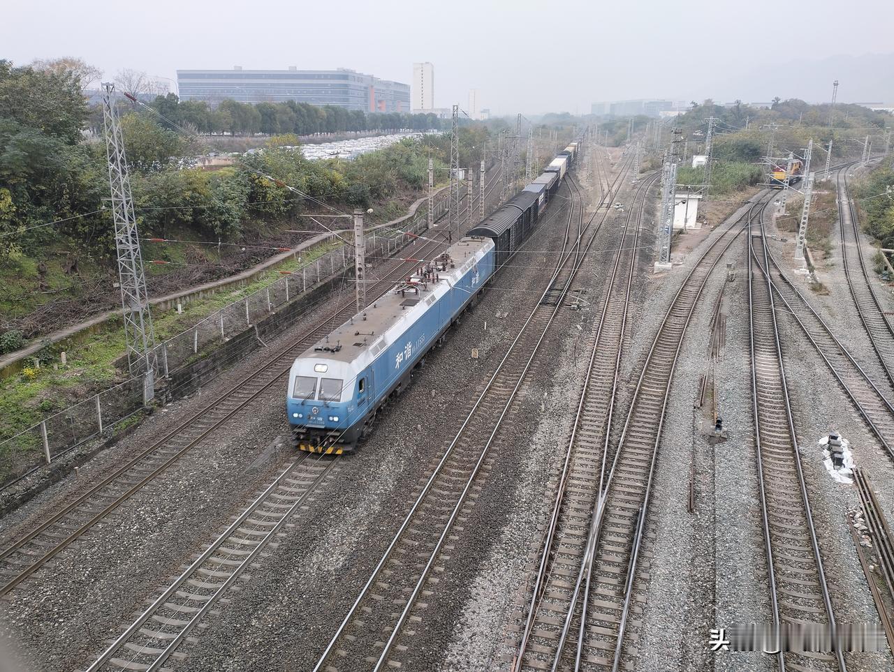 一台和谐1型深度国产化版的电力机车牵引货运列车通过团结村， 这款机车十几年前开始
