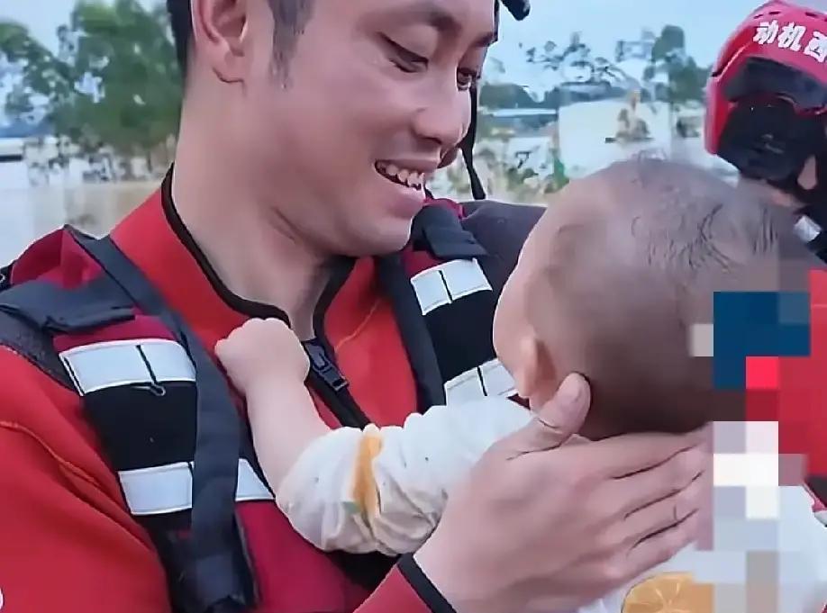 近日，广西南宁，一名救援人员怀抱一名婴儿，只见他一手抱着宝宝，另一只手托着宝宝后