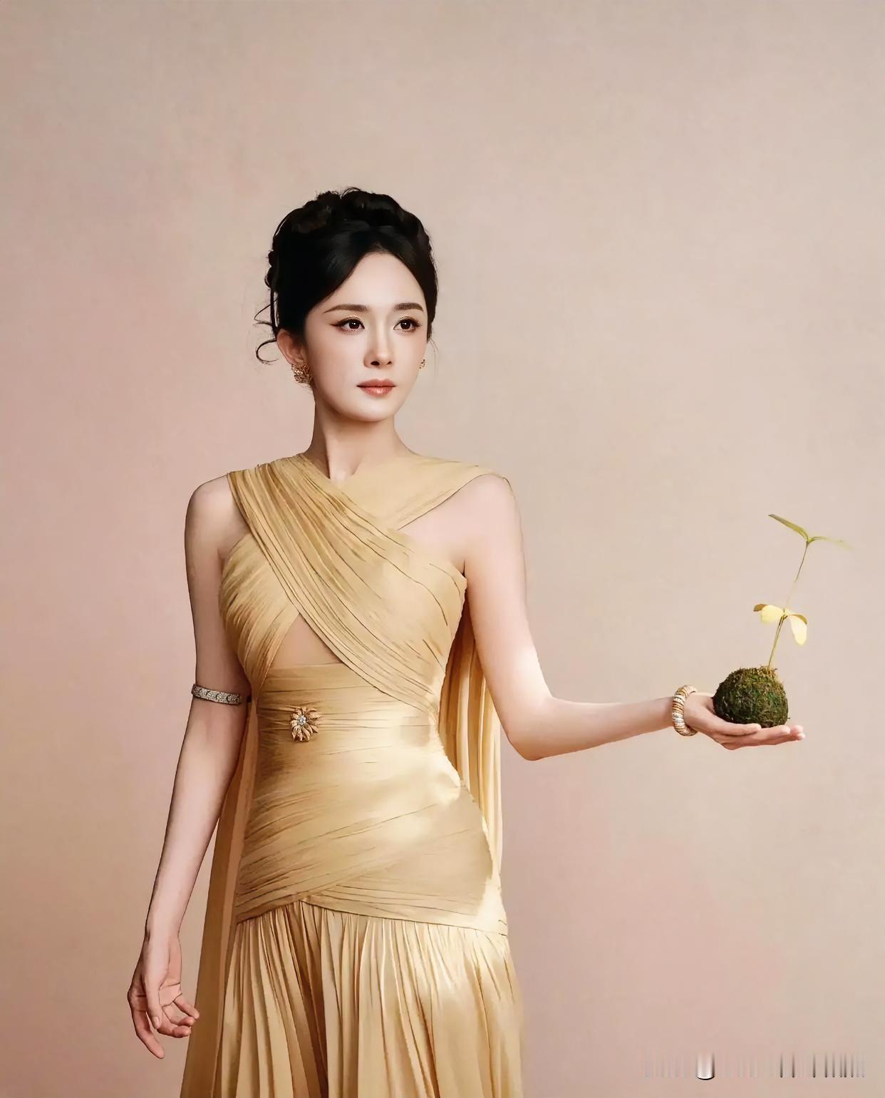 香槟金裙如流云倾泻，缠绕的褶皱勾勒出曼妙身姿。发髻高挽，尽显东方古典气韵。掌心托