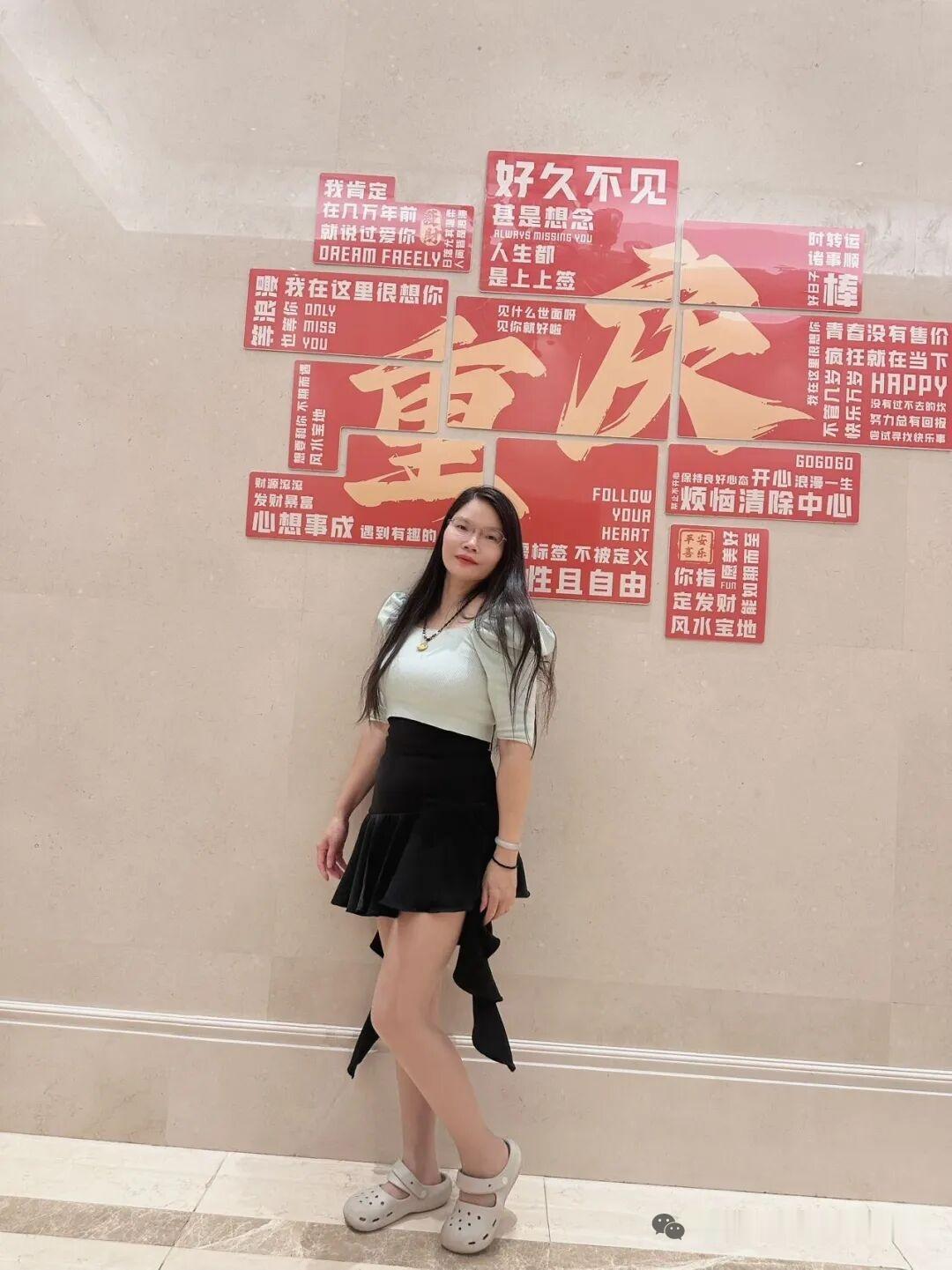 女生站在贴满励志标语的墙前。