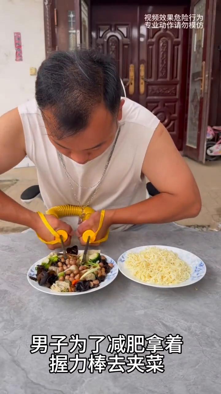 男子减肥用握力棒夹菜，这一幕真的太无奈了。
中午吃饭时间到了，男子为了减肥拿着握