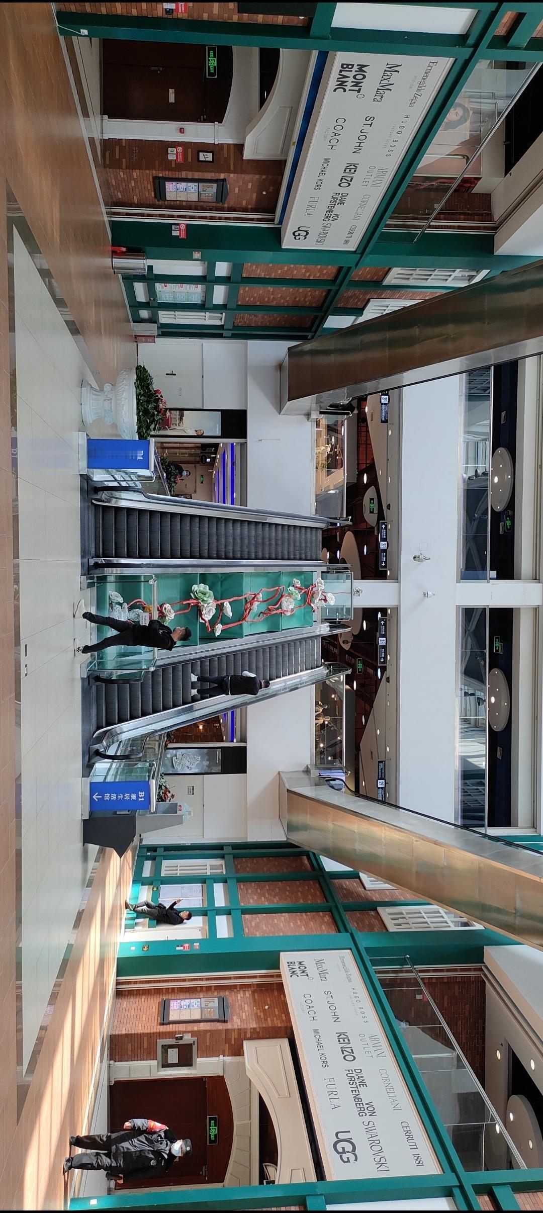 宽敞明亮的商场，自动扶梯带你直达二楼，购物体验更上一层楼！🛍️👟