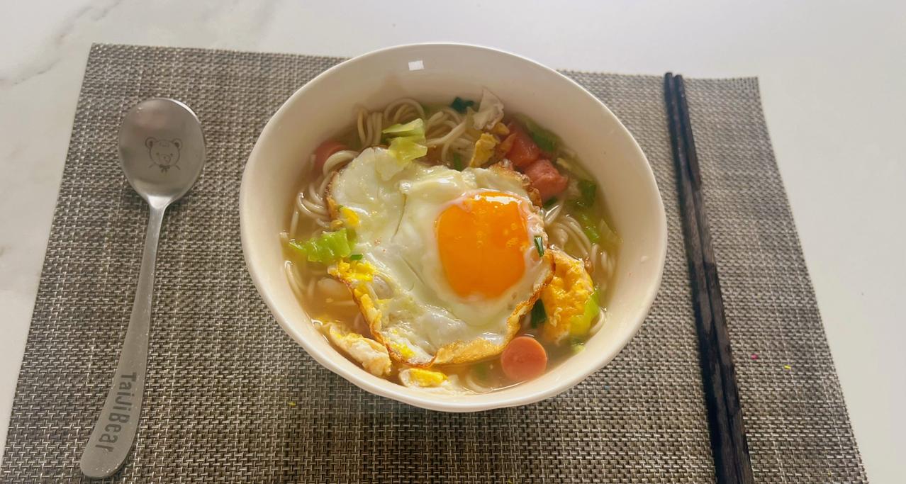 早餐：面条，三个人的量，三个鸡蛋一根火腿肠，一小把面条，几片生菜叶子，一根葱，大