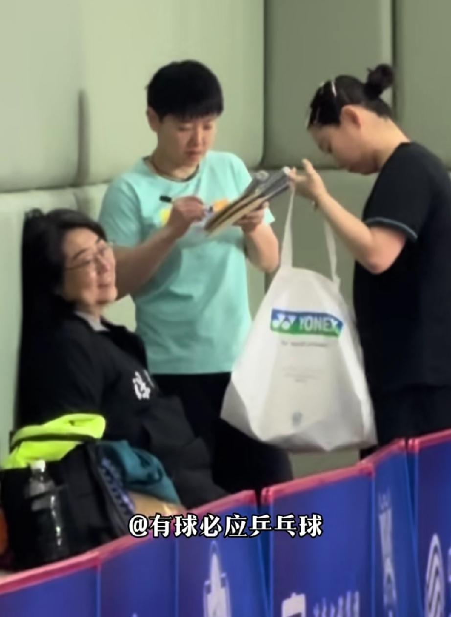 也就高女士和佳佳能这样使唤莎莎了。
佳佳拿着球拍、布兜给莎莎。让莎莎签名。让签球