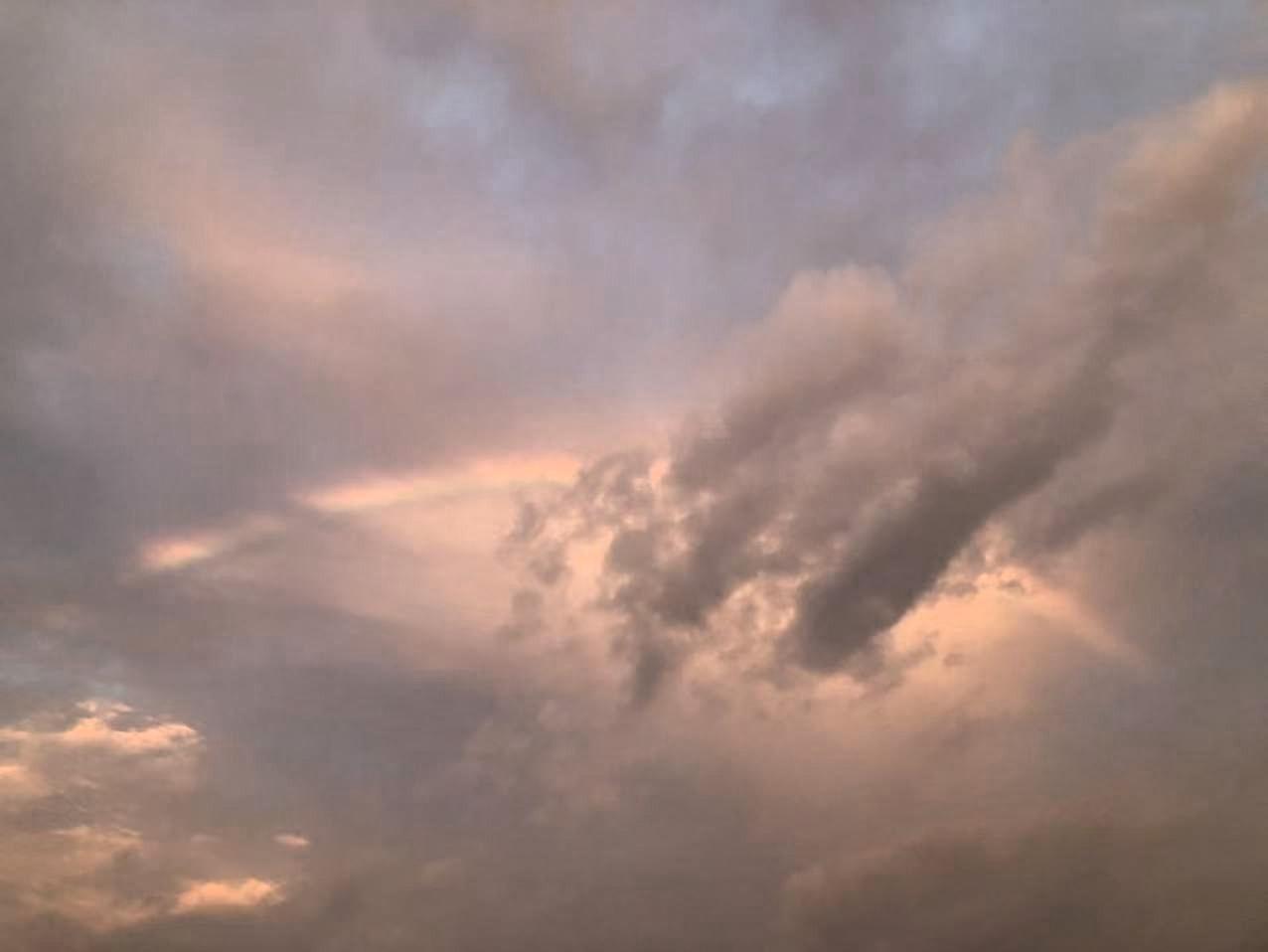 天像浸在淡粉的雾里。云团裹着黄昏的余温，边缘晕开软绒绒的橘粉，暗处又沉成浅褐的雾