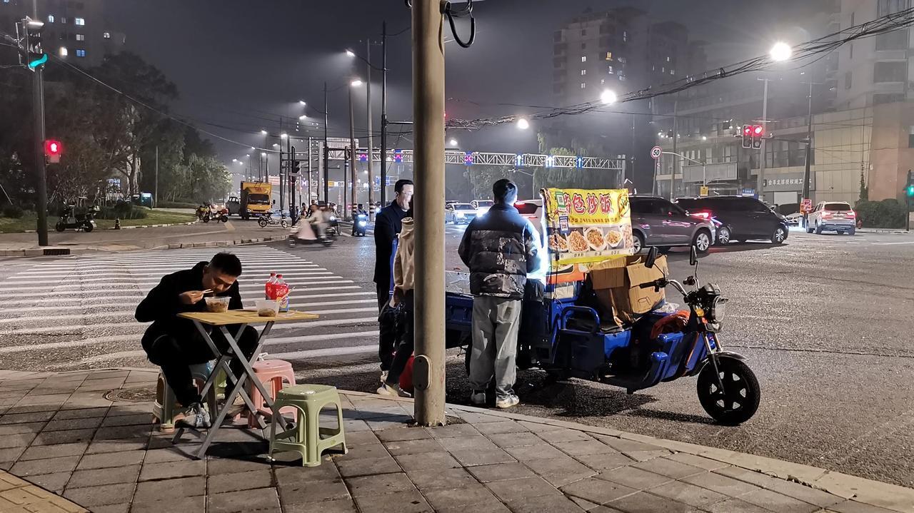 上海夜间的街头，越来越多地出现这种流动式的小吃摊。像这里的炒河粉、炒米粉、炒面、