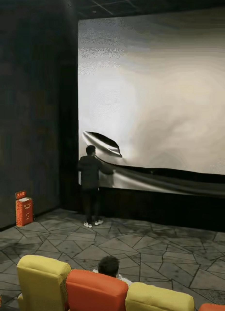 电影院里，一名男子不知为何突然情绪失控，竟径直冲上舞台，持刀反复割划电影银幕。