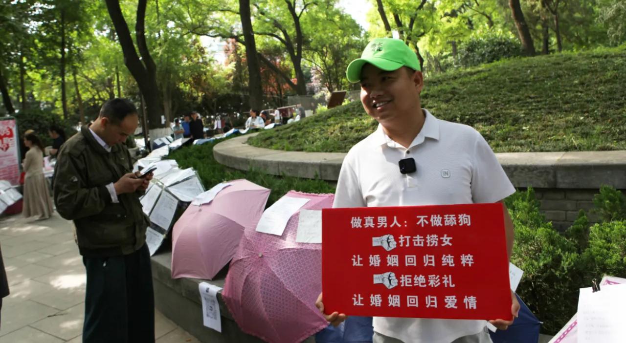 大哥戴着亮眼的绿帽子，在相亲角举着牌子大声喊话，口号一套一套：拒绝彩礼，打击捞女