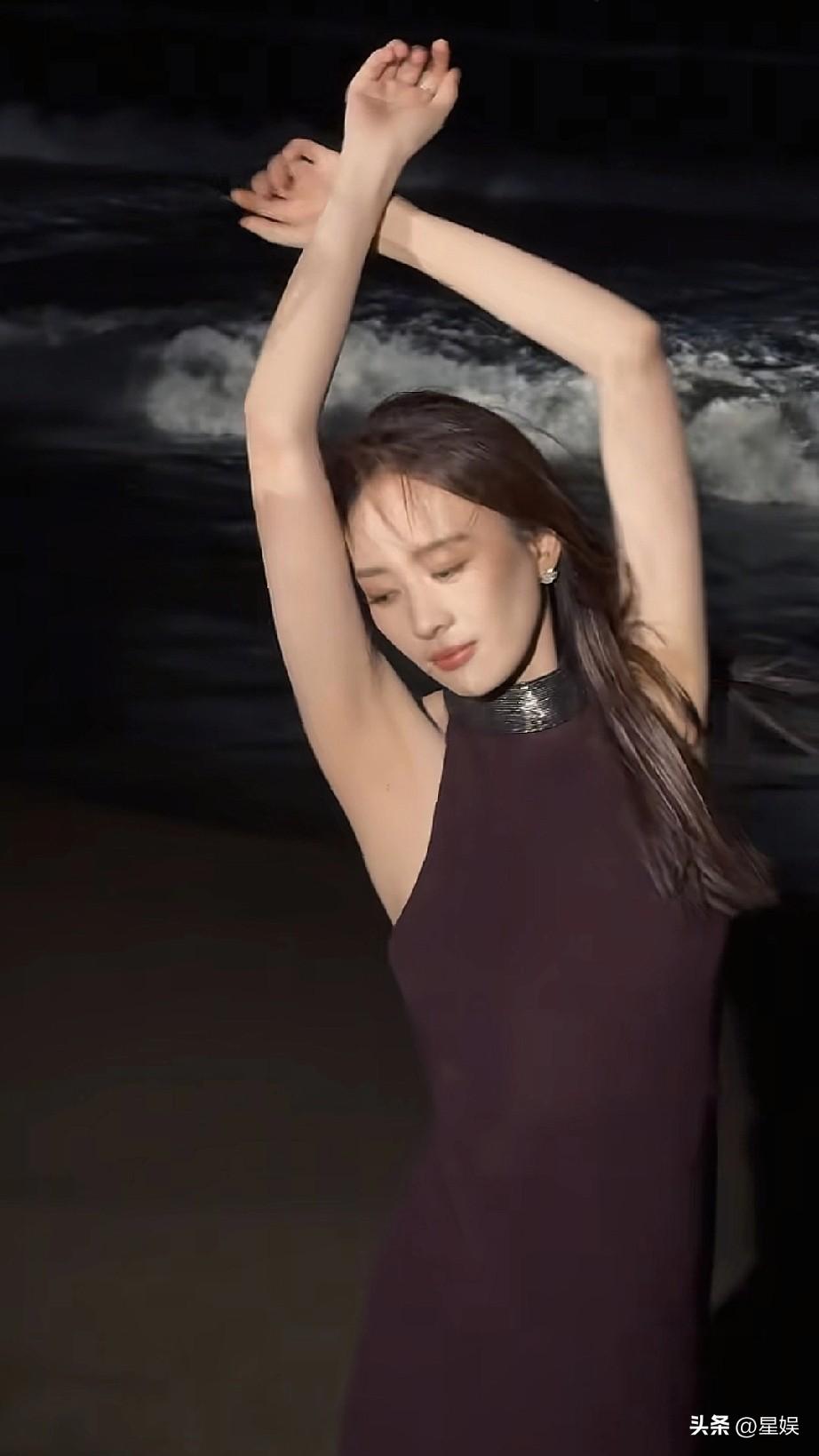 童谣紫色裙子，提着高跟鞋在海边