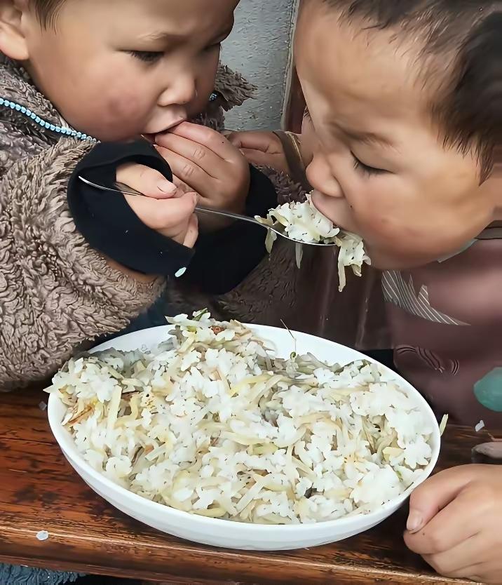双胞胎兄弟，吃饭的时候还是挺温馨，哥哥手里拿着勺子给弟弟喂一口，自己也喂一口，吃