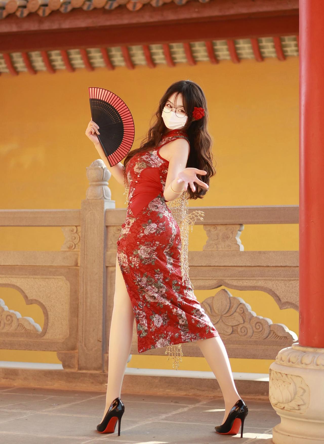红墙黄瓦下，一袭红旗袍赴旧约。阳光穿过檐角，落在蕾丝的花纹上，玫瑰别在发间，折扇