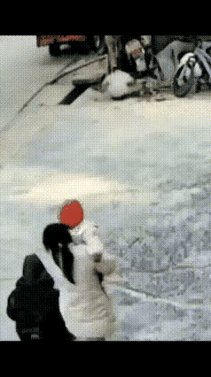 明显看得出来，地面上有雪，地面特别的滑，正是由于地面滑，她的身体才失去了平衡，但