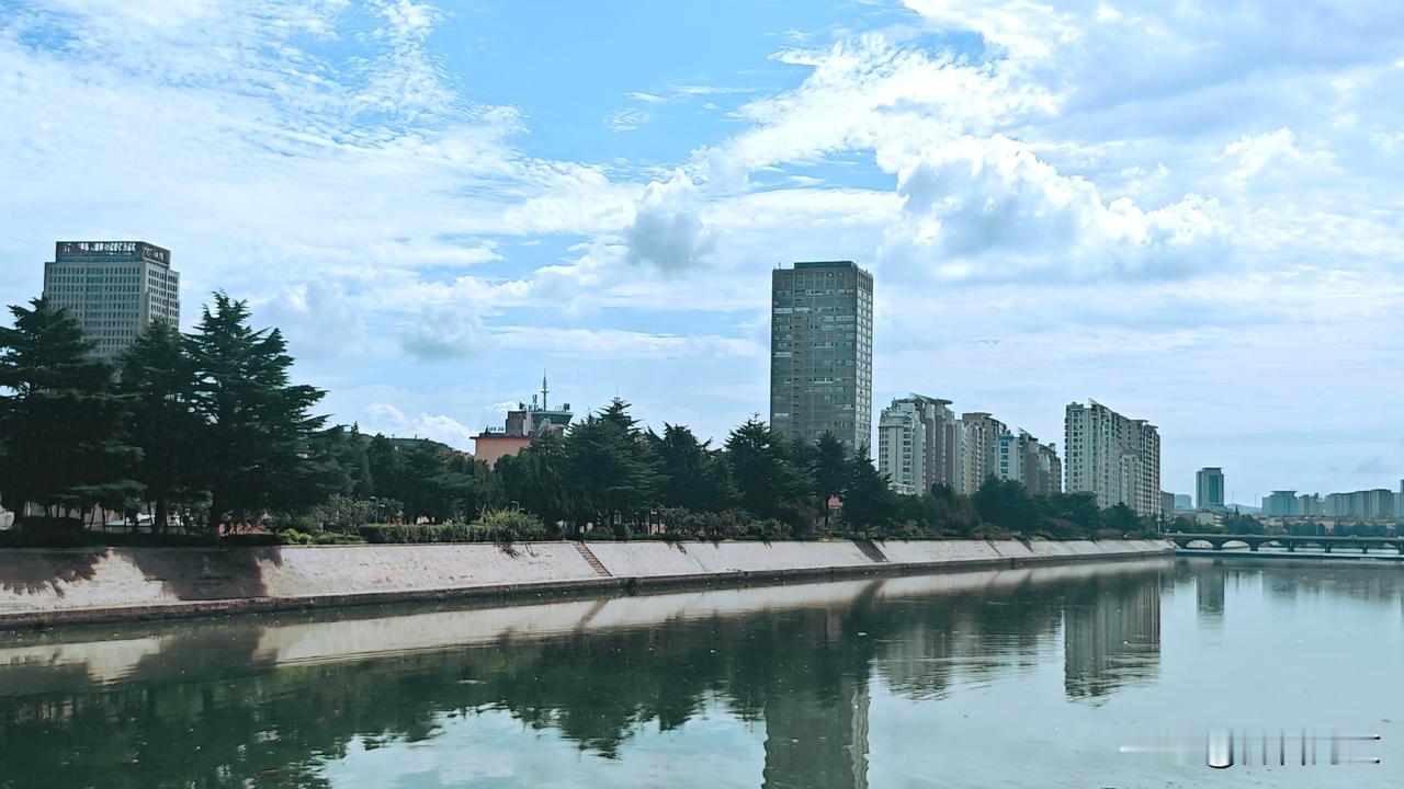 抱龙河岸边高楼大厦巍然屹立在蓝天白云之下