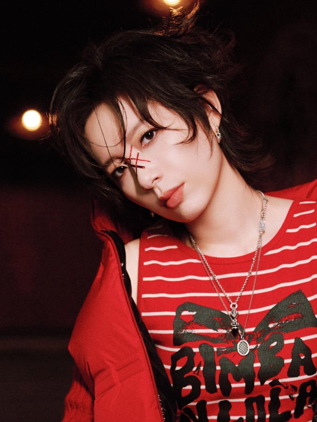 李斯丹妮一身炽烈红装直接把氛围感拉满——无袖羽绒马甲叠针织袖套，格纹裙摆藏在阔腿