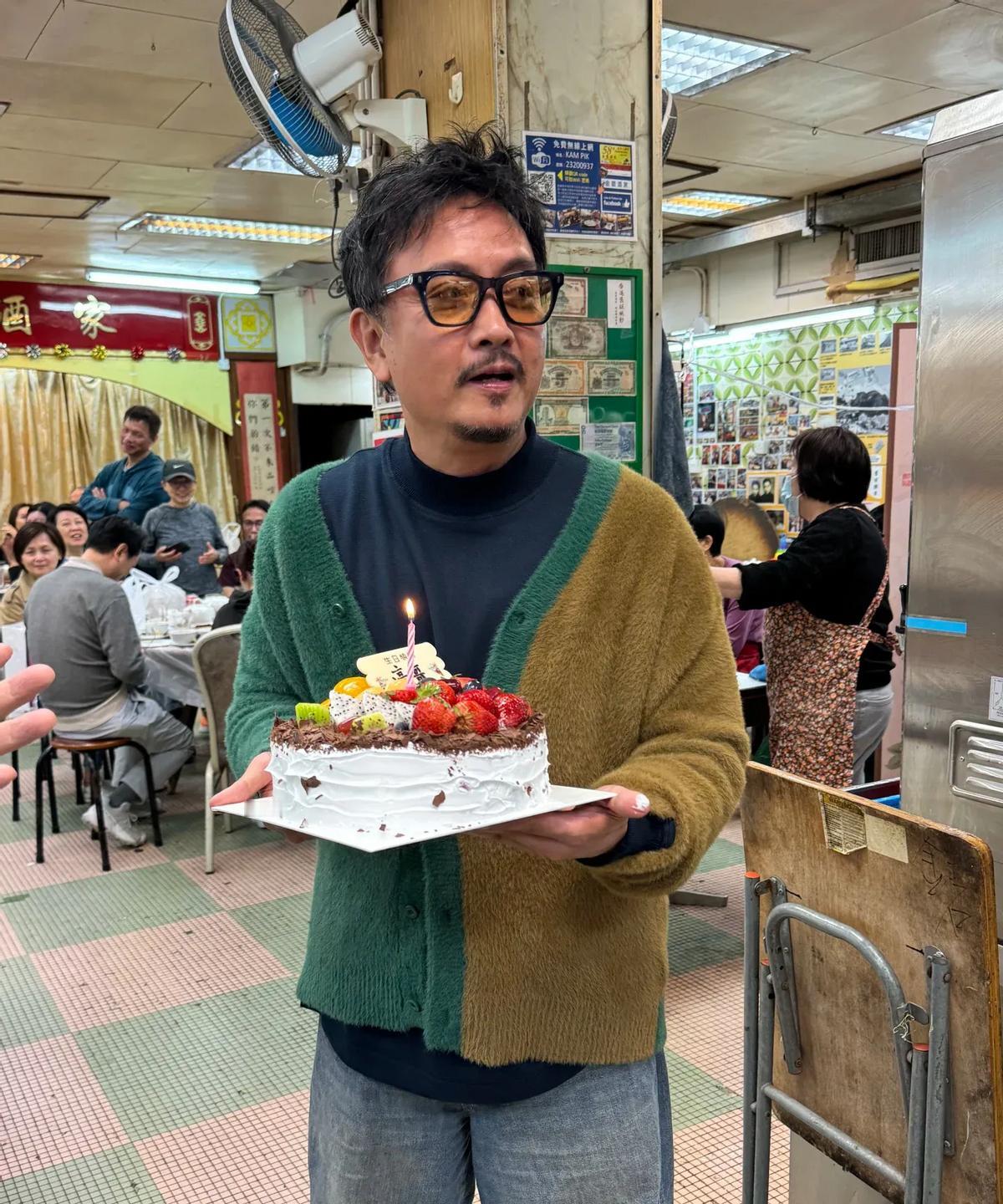 香港影帝谢君豪62岁生日在一家简陋饭店庆祝，桌子陈旧，地面瓷砖破损，柱子开裂。