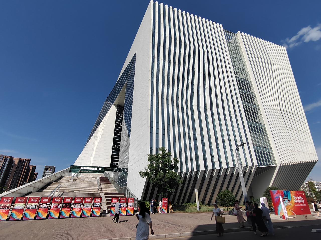 川大江安体育馆，在澄澈蓝天映衬下尽显现代建筑之美。竖向立面线条利落大气，巨型台阶