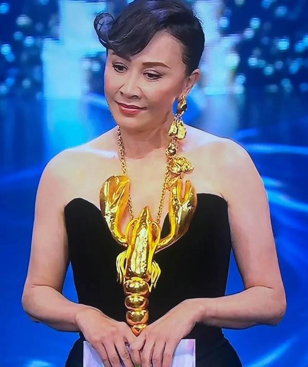 刘嘉玲亮相金像奖，身穿黑色抹胸长裙，脖子上戴着纯金打造的龙虾项链，看着估计有个1