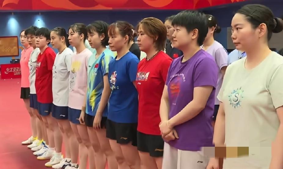 刷到这张国乒女队列队的图
一眼就看到穿紫色T恤的莎莎，只有她把双手轻轻交叠放在身