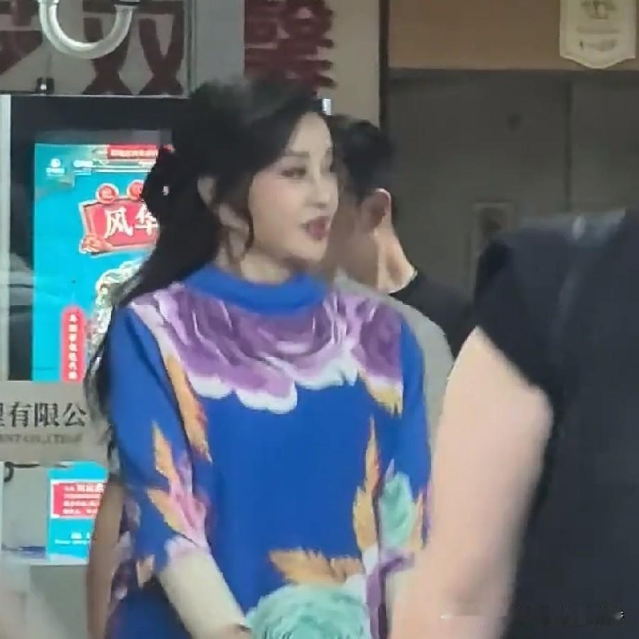 刘晓庆现身商业活动，身着一条蓝色大花连衣裙，走起路来步伐矫健，全然不见老年人的疲