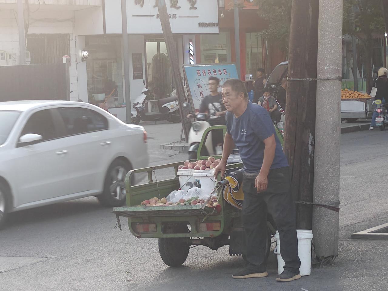 当夕阳的余晖洒在运城盐湖西街早市口，一位农村大叔，他弓着腰，腿微弯，显然是腿疼，