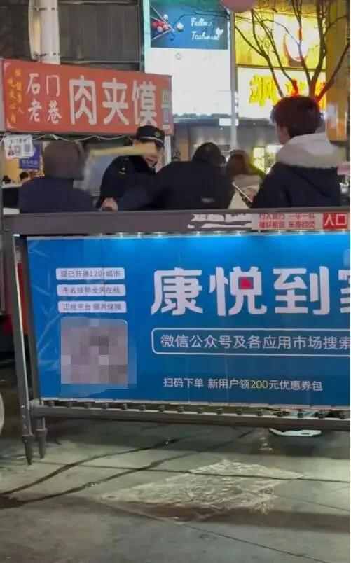河北石家庄。
几名城管人员围着一个卖肉夹馍的摊贩，忽然摊贩拿起折叠板凳砸向一人头