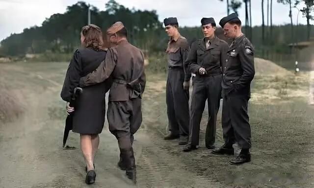 1945年，柏林，一个苏联士兵搂着自己的德国情人走过时，旁边的三名美国大兵投来羡