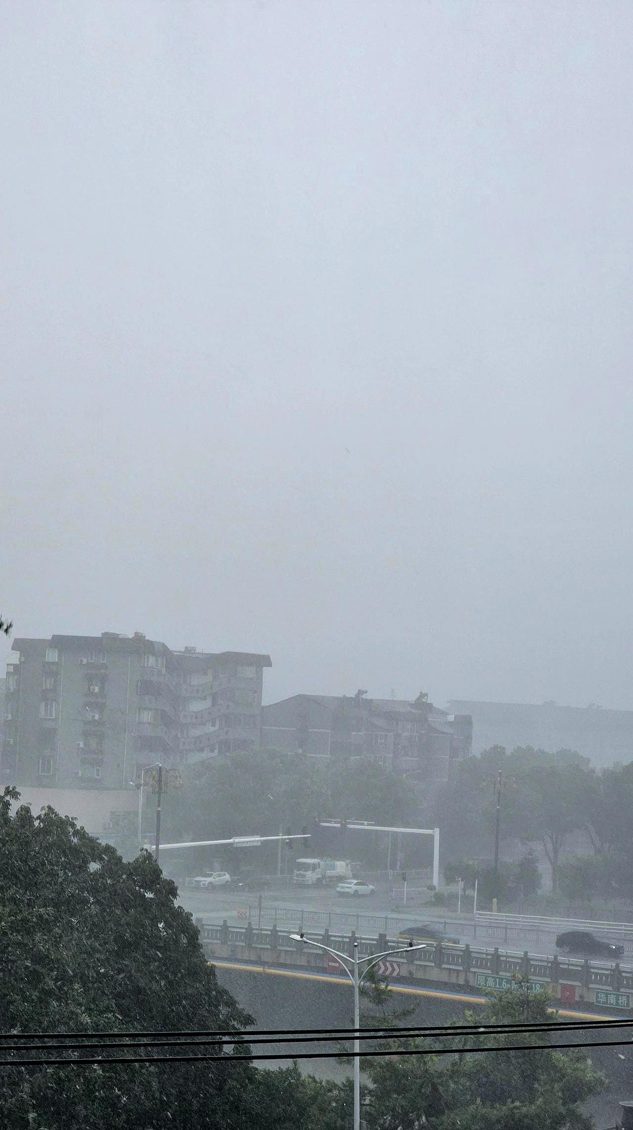 丹阳城区这会儿，天像被人捅开了口子，雨砸得路面发白，风一阵紧过一阵，行人走在街上