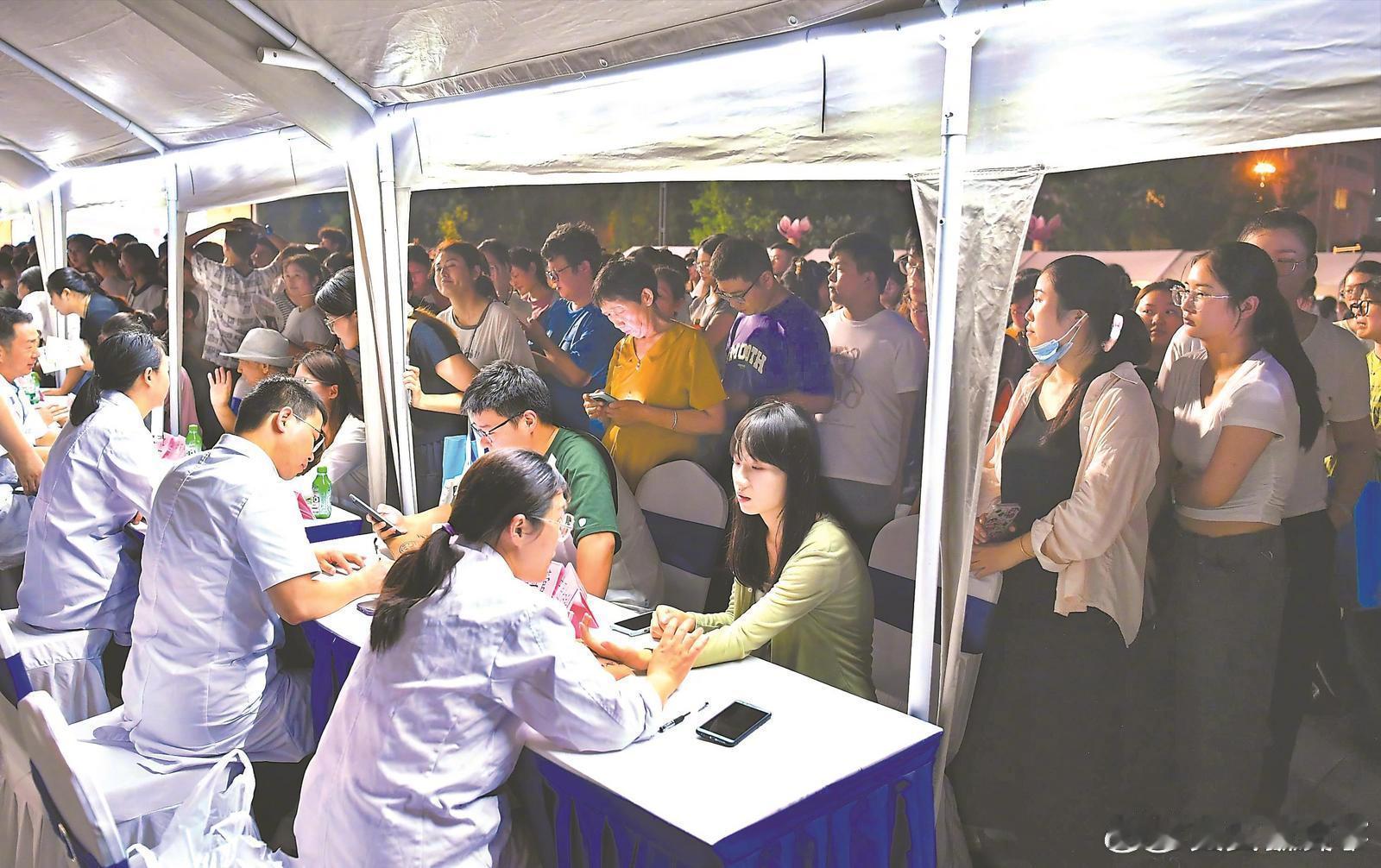 【#合肥中医专家坐诊夜市#】8月22日晚，在合肥市天鹅湖市民广场，中医专家为市民
