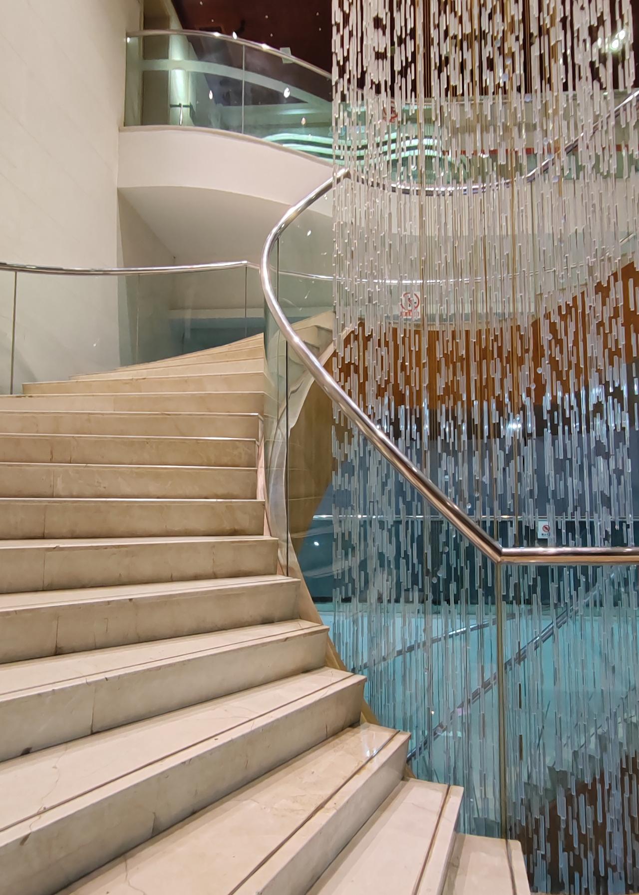 蜿蜒而上的台阶，像是通往生活更高处的幽径，身旁晶莹的珠帘随光摇曳，一步一景，皆是