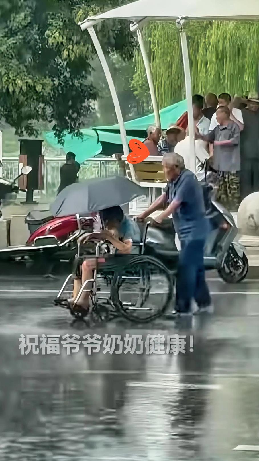 看到这画面，

真的一下子破防了！

大雨天，大爷推着坐轮椅的老伴，自己淋着雨，