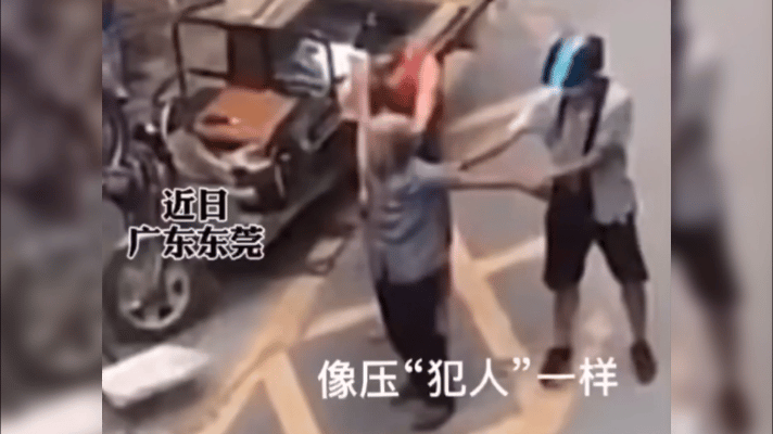 广东东莞，两个男子一人拉住老人一条胳膊，画面像极了犯罪指认现场。他们站在一辆卡车